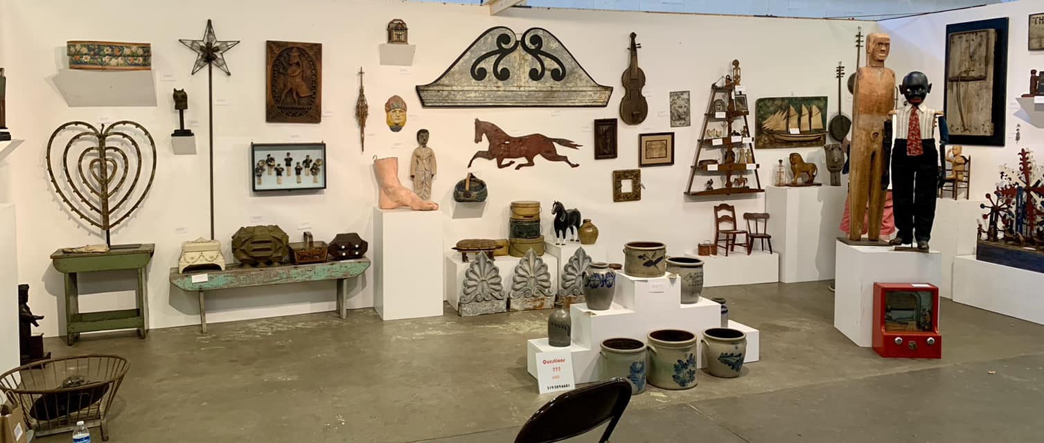 Museum-style display of antique and vintage objects on pedestals
